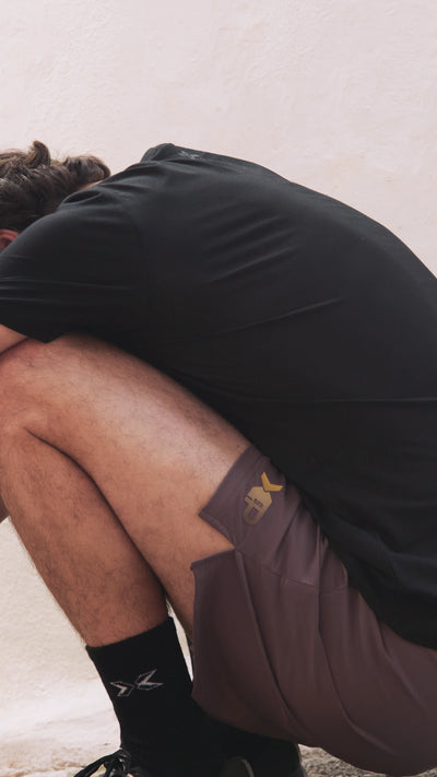 Hombre en cuclillas con pantalones cortes de picsil